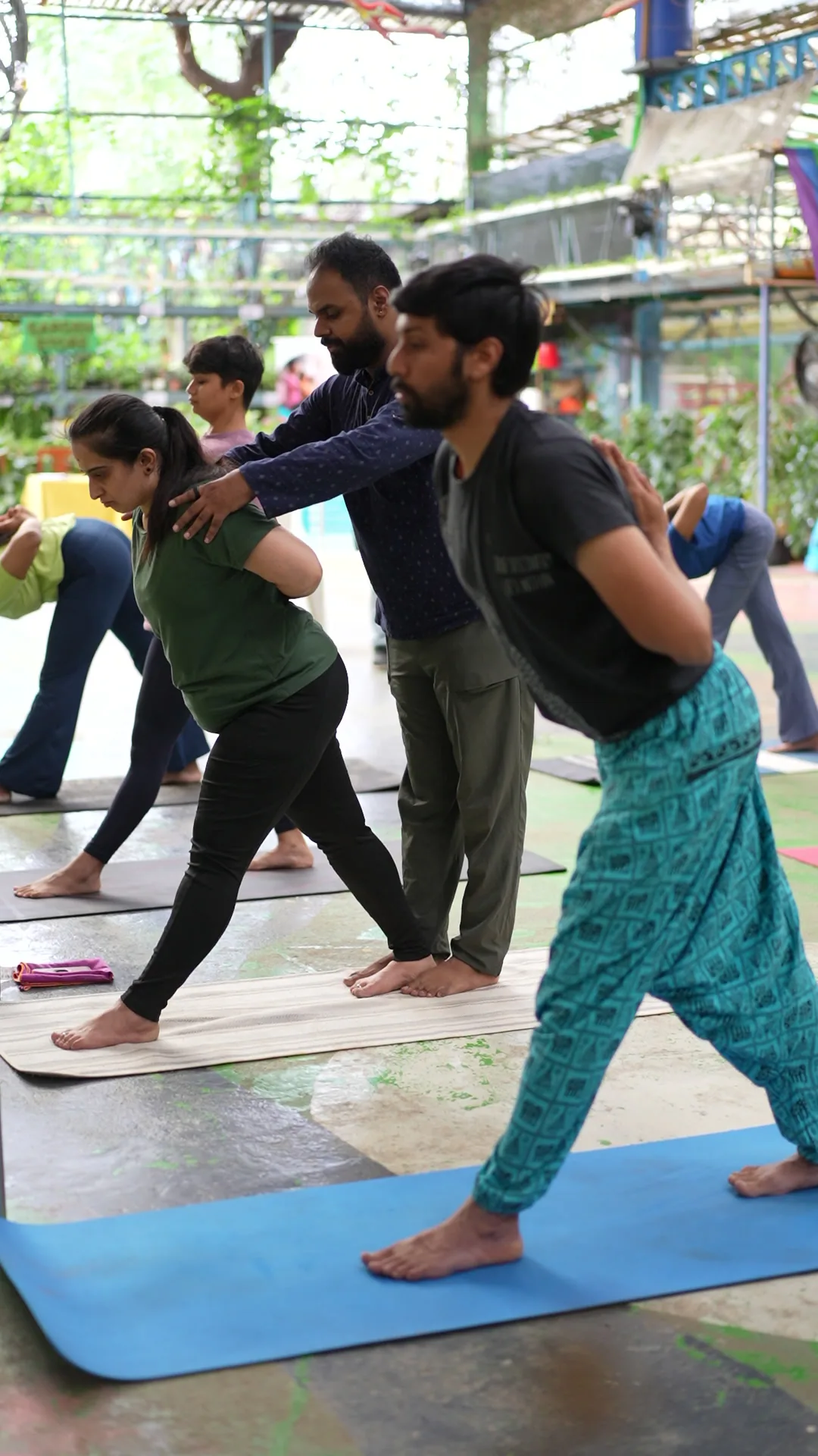 A teacher guiding a student with a hand on her back during a class
